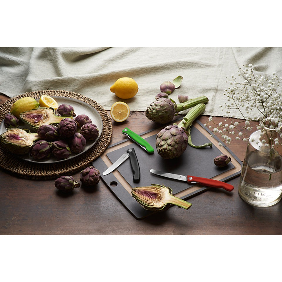 victorinox inklapbare schilmessen glad 11 cm rvs rood zwart en groen kunststof op snijplank op tafel