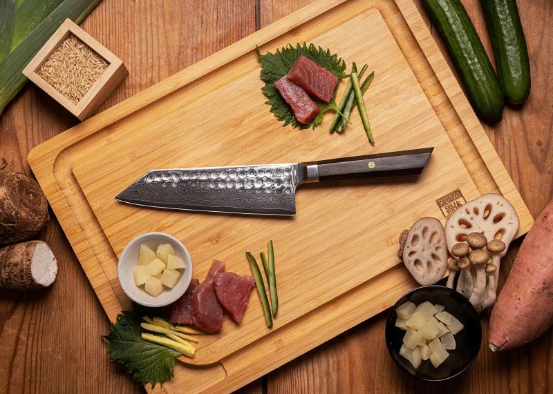 kotai bunka damascus santokumes 18 cm ebbenhout op houten snijplank met vlees en groente