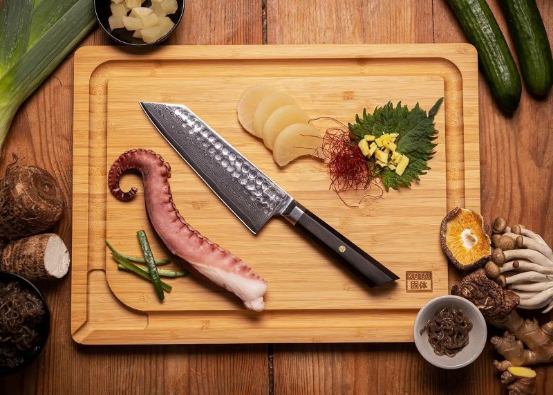 kotai bunka damascus santokumes 18 cm ebbenhout op houten snijplank
