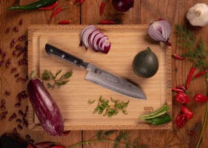 KOTAI Hashi Damascus Santokumes met lemmet van 17 cm op een houten snijplank