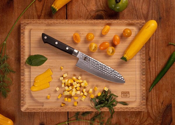 KOTAI Hashi Tsuchime Santoku met 17 cm lemmet op een houten snijplank