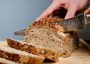 bruin brood snijden met kotai pakka damascus broodmes 20 cm pakkahout op snijplank