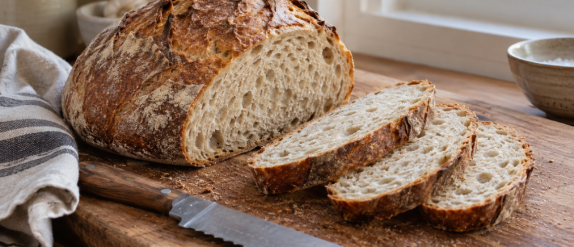 Rustiek brood met gelijkmatige sneetjes naast een broodmes